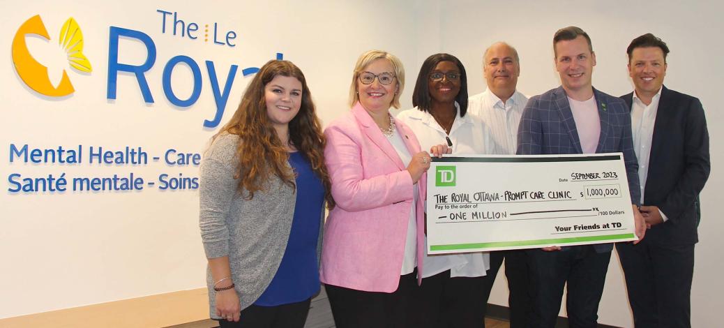 Group of people holding a large cheque