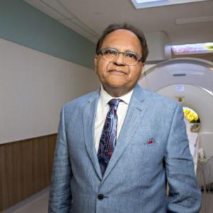 Zul Merali standing in front of MRI machine