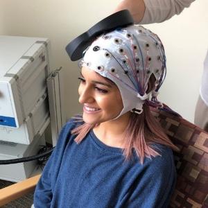 Une femme portant une casquette pour la stimulation magnétique transcrânienne répétitive (rTMS)