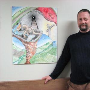 Mike, a member of the Client Advisory Council at the Brockville Mental Health Centre stands by his painting